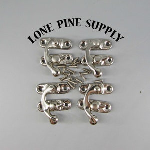 May include: Six silver-toned metal clasps with a rounded hook design. The clasps are arranged in a circle with a pile of small silver screws in the center. The text "LONE PINE SUPPLY" is printed in black above the clasps.