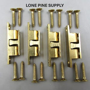 May include: A set of brass-colored ball catches and matching screws. The image shows four ball catches with two screws each, and the text "LONE PINE SUPPLY" at the top. These are likely for cabinet doors or drawers.