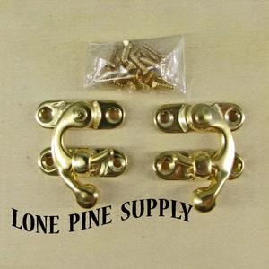 May include: Two gold-toned metal hook and eye clasps with screws. The clasps are designed to be used for securing boxes, chests, or other items.  Lone Pine Supply is printed below the clasps.
