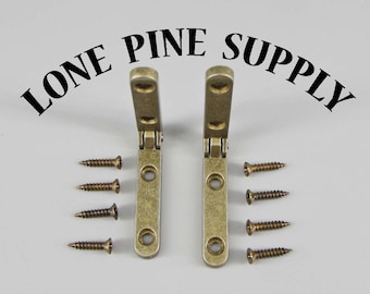 May include: Two antique brass hinges with four screws. The hinges are closed and the screws are loose.