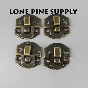 May include: Four antique brass-toned box clasps with a rounded rectangular shape and a hinged latch. Each clasp has four small holes for attaching to a box or other project.