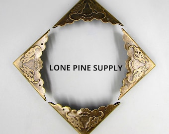 Könnte beinhalten: Vier antike goldene Eckenschutz mit einem dekorativen floralen Design. Lone Pine Supply.