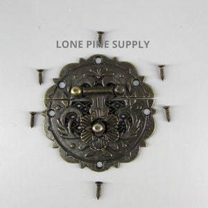 May include: Antique brass-toned metal latch with ornate floral design. The latch has a round shape with a scalloped edge and includes six screws for installation.  The text "LONE PINE SUPPLY" is visible in the image.