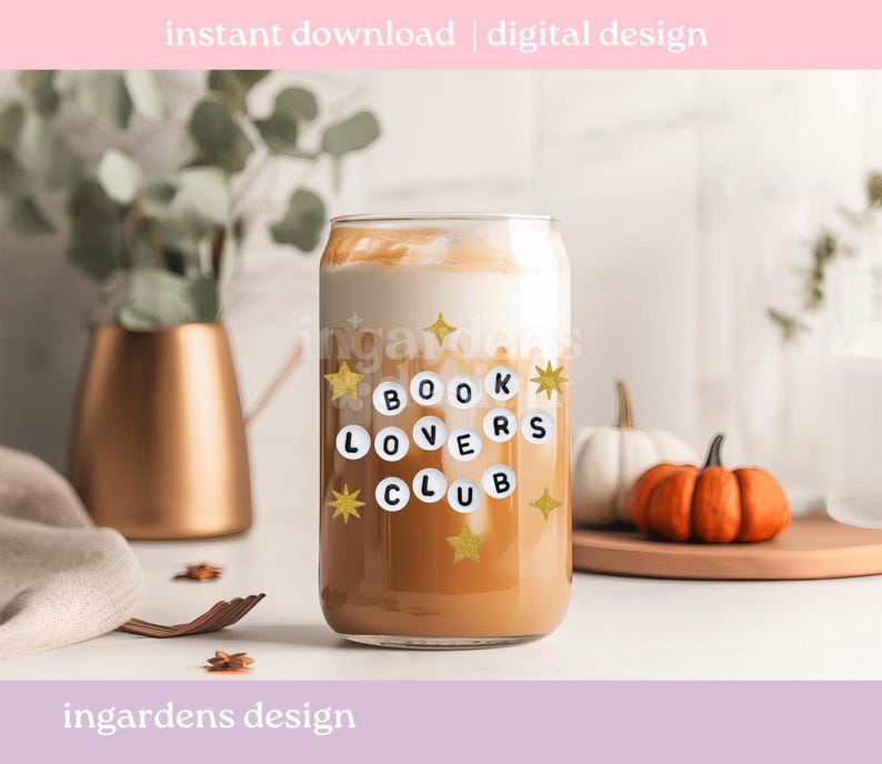 Pu&ograve; includere: Un bicchiere trasparente a forma di lattina pieno di una bevanda a strati. Il bicchiere presenta la scritta "BOOK LOVERS CLUB" in un design circolare con stelle dorate. L'immagine include anche zucche e un vaso dorato.