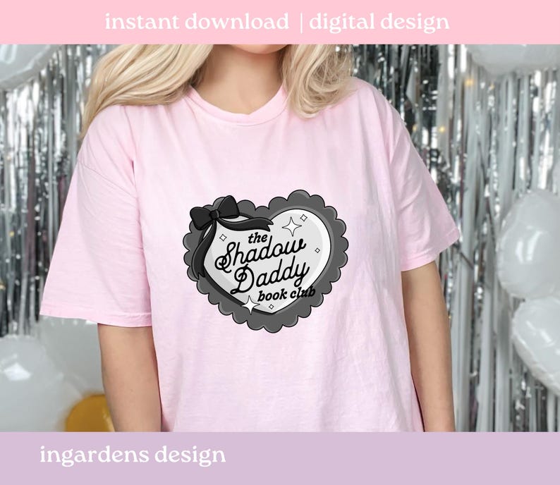 May include: A light pink t-shirt featuring a heart-shaped graphic with the text "the Shadow Daddy book club". The graphic is black and white with a black bow and decorative border. The words "instant download | digital design" are at the top.
