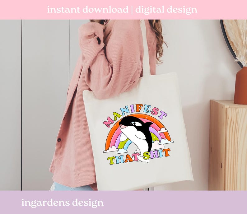 K&ouml;nnte beinhalten: Cremefarbene Tragetasche mit einem Cartoon-Orca-Wal-Design, einem Regenbogen und den Worten "MANIFEST THAT SHIT". Die Tasche hat auch den Text "instant download | digital design" und "ingardens design".