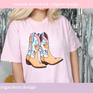 May include: A light pink t-shirt featuring a graphic of two cowboy boots. The boots are tan with blue and pink accents, and are decorated with seashell illustrations. The text "instant download | digital design" is at the top.