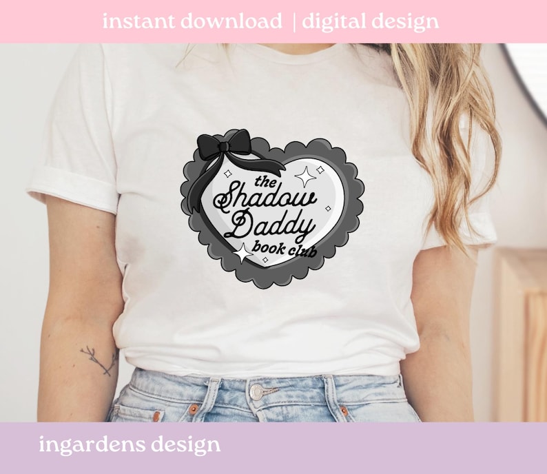 May include: White t-shirt featuring a heart-shaped design with the text "the Shadow Daddy book club". The design is in black and gray, with a bow at the top. The words "instant download | digital design" are at the top.