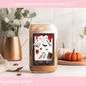 May include: A glass coffee cup with a spooky design featuring a red blood splatter, a knife, a bat, a skull, and the words "HORROR Book Club". The cup is filled with a creamy beverage and is decorated with a digital design.
