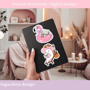 May include: Two stickers on a black tablet. One sticker is a pink flamingo float with books. The other is a white ghost reading a book in a beach chair with a pumpkin. Text at the top says "instant download | digital design".