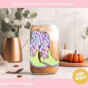 May include: A digital design for a cup wrap featuring a pair of colourful cowboy boots with a celestial pattern. The boots are on a light brown background with the text "CUP WRAP" in a yellow circle.
