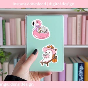 May include: A digital design featuring two stickers. One sticker shows a pink flamingo float with books and a drink. The other sticker shows a ghost reading a book on a lounge chair with a pumpkin. Text at the top says "instant download | digital design".