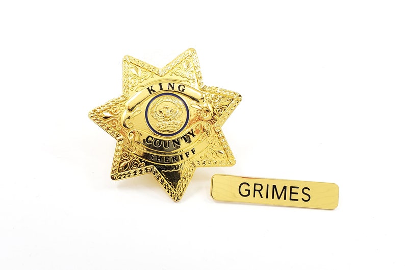 May include: Gold sheriff's star badge with the words "King County Sheriff" and a name tag that reads "Grimes".