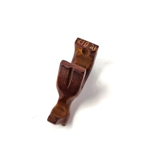 May include: A wooden, brown, U-shaped object with a carved design. The object is made of wood and has a smooth, polished finish.