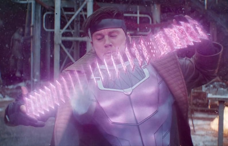 Może przedstawiać: Osoba w fioletowo-białym kostiumie, z czarną opaską na głowie, wydycha energię. Energia przejawia się jako seria świecących, r&oacute;żowych, prostokątnych kształt&oacute;w. Tło to rozmyte otoczenie przemysłowe.