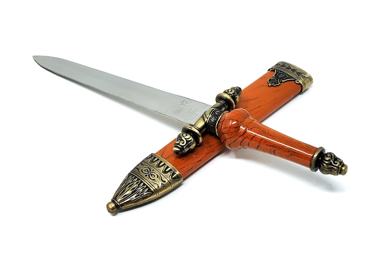 May include: A decorative dagger with a brown wood-look handle and a silver blade. The handle has ornate gold accents and the blade is sheathed in a matching brown scabbard.