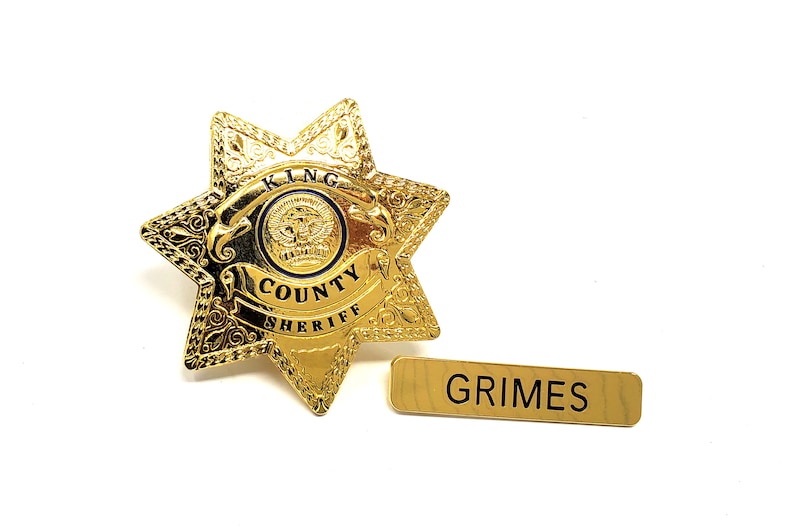 May include: Gold sheriff's star badge with the words "KING COUNTY SHERIFF" and a name tag that reads "GRIMES".