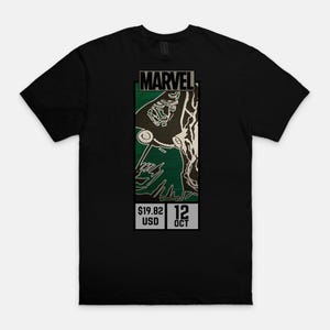 May include: Black t-shirt featuring a Marvel graphic. The graphic includes the Marvel logo, a green and white illustration, and the text "$19.82 USD 12 OCT".