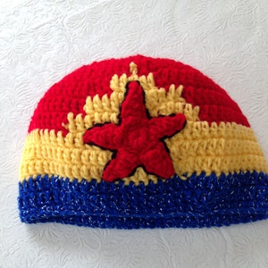 May include: A crocheted hat with a red, yellow, and blue color scheme. The hat features a red star in the center.