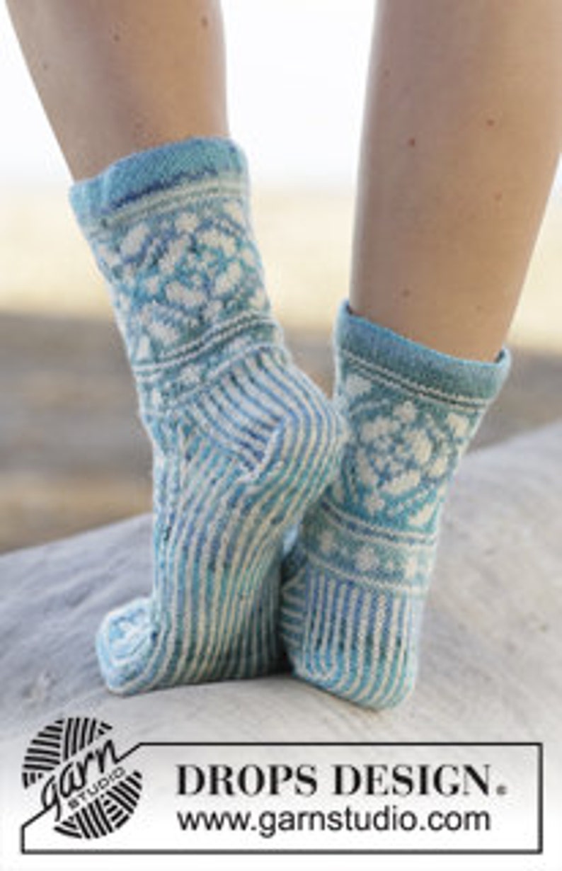 K&ouml;nnte beinhalten: Ein Paar blau-wei&szlig; gestreifte Socken mit einem geometrischen Muster am B&uuml;ndchen. Die Socken sind aus einem weichen, komfortablen Garn gefertigt und perfekt f&uuml;r den Alltag.