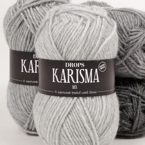 Puede incluir: Tres ovillos de lana gris con una etiqueta que dice "DROPS KARISMA MIX. Un cl&aacute;sico de lana tratada superwash."