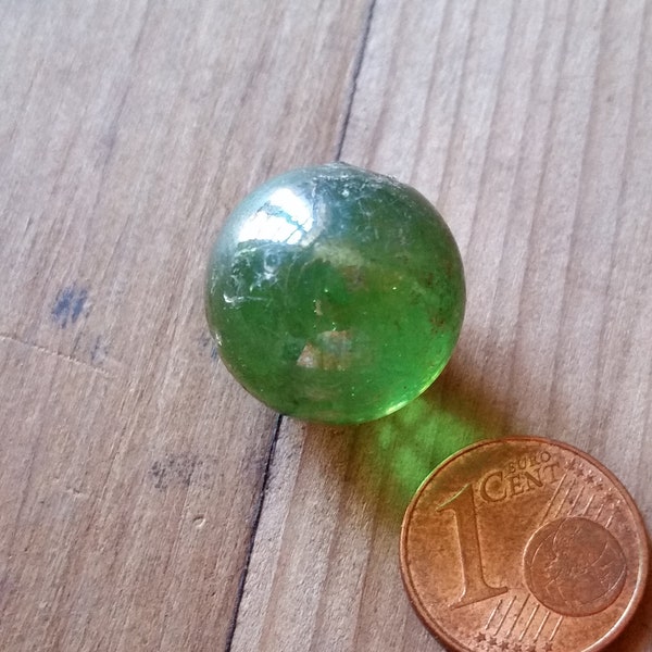 1920s HAND BLOWN MARBLE, transparent bottle green glass with air bubbles and pontil mark. Unique game of marbles collectors piece.