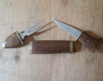 Vintage FISHERMAN'S KNIFE and FORK Carving Set in fish shaped carved wooden holder with brass fins and fittings.