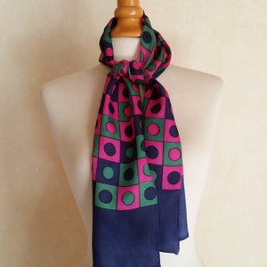 May include: A navy blue silk scarf with a geometric pattern of pink and green circles on a white background.