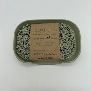 May include: A green soap dish made of eco-friendly bio plastic. The dish has a raised center to keep soap bars elevated and dry. The dish is labeled "SOAP LIFT&reg; Eco Friendly bio Plastic Bar soap will last longer. No messy residue. Just rinse under running water! BPA & Phthalate Free Made in USA"
