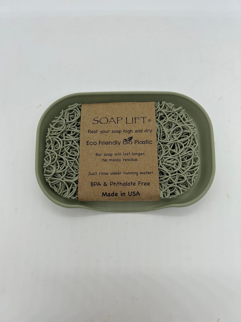May include: A green soap dish made of eco-friendly bio plastic. The dish has a raised center to keep soap bars elevated and dry. The dish is labeled "SOAP LIFT&reg; Eco Friendly bio Plastic Bar soap will last longer. No messy residue. Just rinse under running water! BPA & Phthalate Free Made in USA"