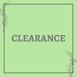 May include: A light green square graphic with the word "CLEARANCE" in gray, centered. The graphic is framed by a gray border and features delicate floral illustrations in the corners.