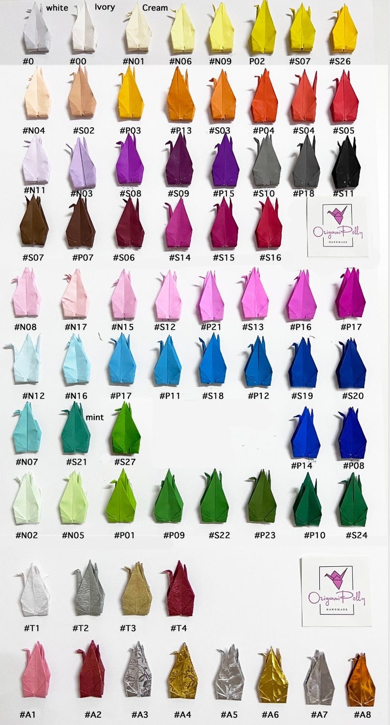 May include: A collection of origami cranes in various colours, including white, ivory, cream, orange, pink, purple, blue, green, red, gold, and silver. The cranes are arranged in rows on a white background. Each crane is labelled with a number.