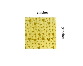 May include: A 3x3 inch sheet of gold foil with a repeating pattern of small hearts.