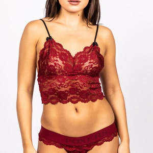May include: Red lace lingerie set with a black trim and the word "Foxers" printed on the waistband.