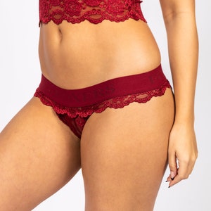 May include: Burgundy lace underwear with a waistband that reads "NYX".