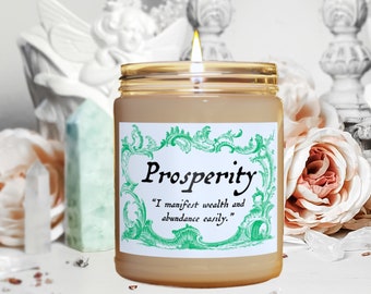 May include: A beige candle in a glass jar with a green and white label that reads "Prosperity" and "I manifest wealth and abundance easily."