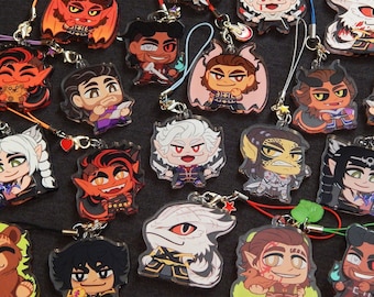 May include: A collection of colorful character charms with various designs, including dragons, demons, and other fantasy creatures. The charms are made of clear acrylic and have a glossy finish. Each charm is attached to a small metal ring and a string.