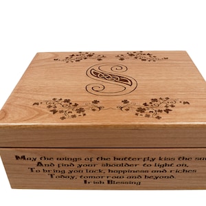 May include: Wooden box with a Celtic knot initial "S" and floral accents. The box features an Irish blessing inscription. The light brown wood has a natural grain, and the design is etched into the surface.