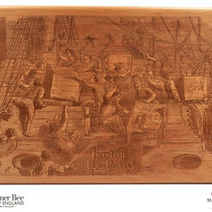 Op de afbeelding: Gegraveerde houten plaquette met een gedetailleerd beeld van een drukke scheepswerfsc&egrave;ne. De plaquette heeft de tekst "Boston Tea Party" in een decoratief lettertype.