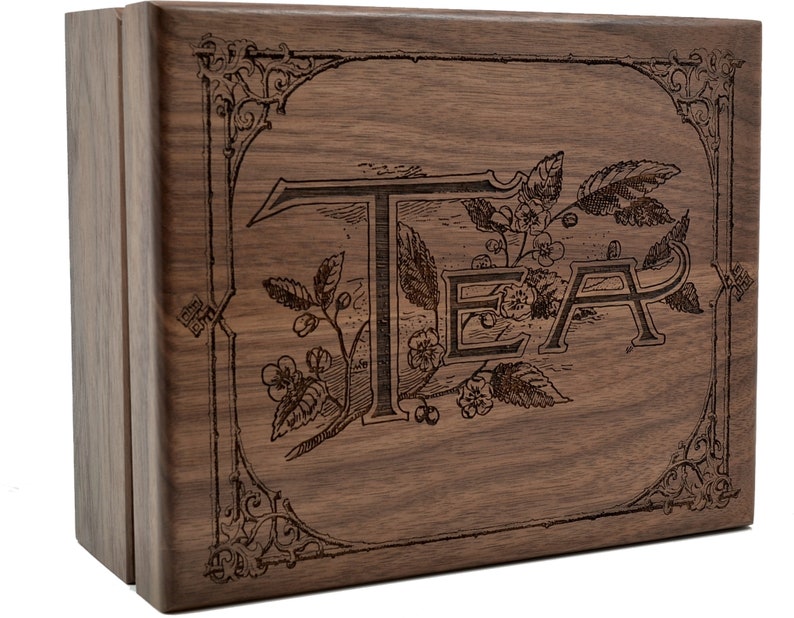 May include: A wooden tea box with an engraved design featuring the word "TEA" surrounded by leaves and flowers.