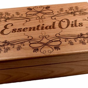 May include: A wooden box with an engraved design of flowers, bees, and the words "Essential Oils".