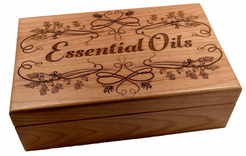 May include: A wooden box with an engraved design of flowers, bees, and the words "Essential Oils".