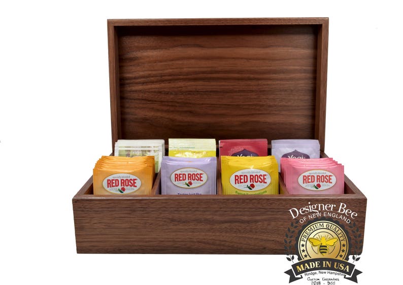 May include: A wooden box with a hinged lid, containing eight tea bags. The tea bags are labeled "Red Rose" and feature a variety of flavors. The box is made by Designer Bee of New England and has a label that says "Premium Quality" and "Made in USA".