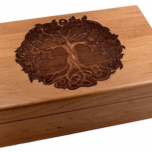 May include: A wooden box with a carved tree of life design on the lid. The box is made of light brown wood and has a natural finish.