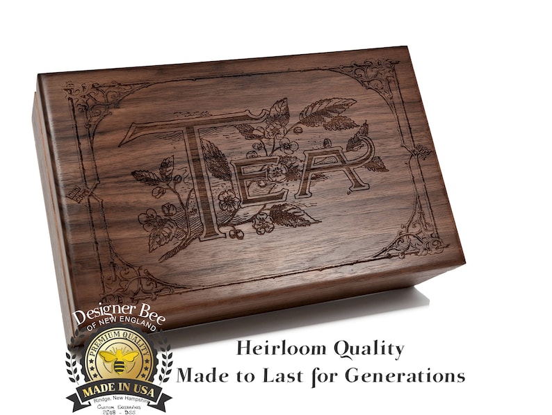 May include: A wooden box with a dark brown finish and an engraved design of leaves and the word "TEA". The box has a label that says "Designer Bee of New England" and "Premium Quality Made in USA".