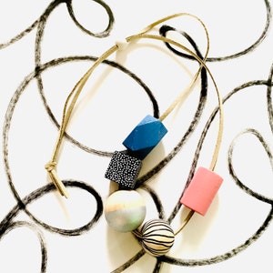 Geometric sphere bead, minimal style wooden statement necklace in pastel colours.