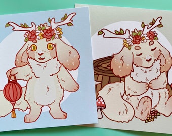 May include: Two illustrations of a white furry creature with antlers and a flower crown. The creature on the left is holding a red lantern. The creature on the right is sitting on a tree stump with mushrooms.