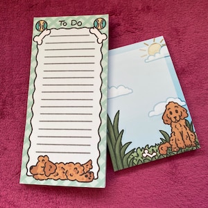 May include: A green and white to-do list notepad with a dog and bone design. The notepad has a lined section for writing tasks and a section with a dog and bone illustration. The text "To Do" is printed at the top of the notepad.
