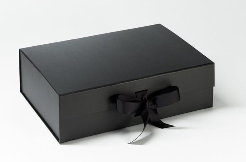 May include: A black gift box with a black satin ribbon tied in a bow.