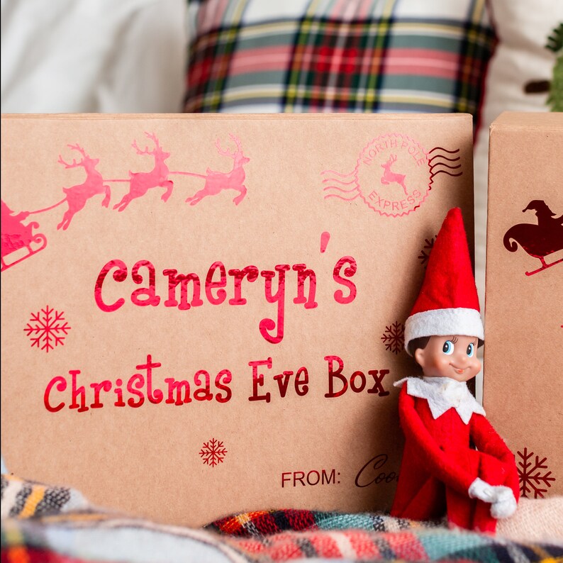 North pole express package from santa. Features a design with Santa and his reindeer flying in the sky. Font is designed to look like an elf hand wrote the lettering.